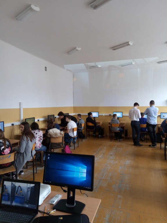 sala lekcyjna z uczniami siedzącymi przed monitorami komputerów widok na nowy parkiet