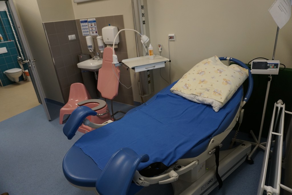 widok sali porodowej - fotel do porosu, umywalka sprzęt medyczny, siedzisko