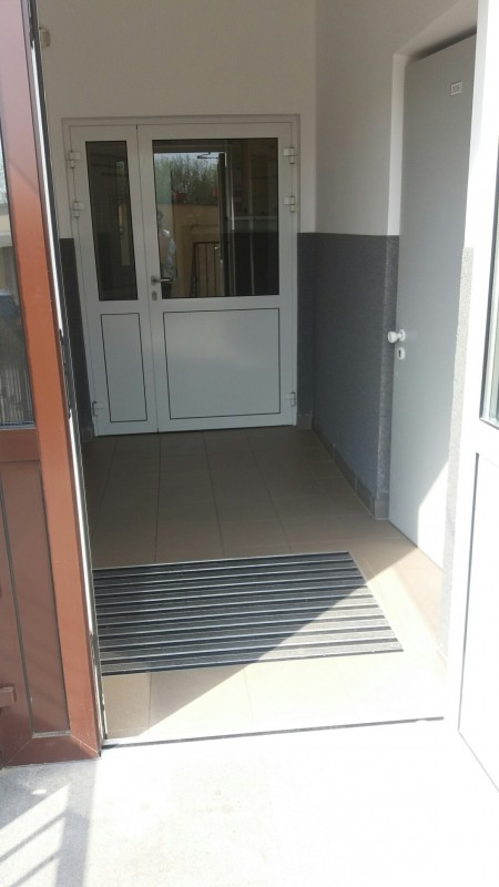 zdjęcie wejścia do budnyku otwarte drzwi wycieraczka przeszklone drzwi