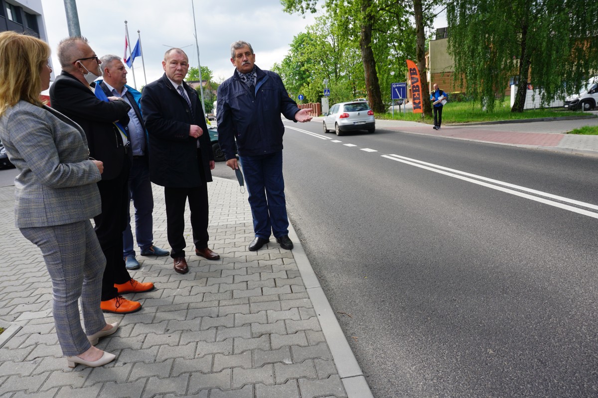 Kilka osób stoi na chodniku