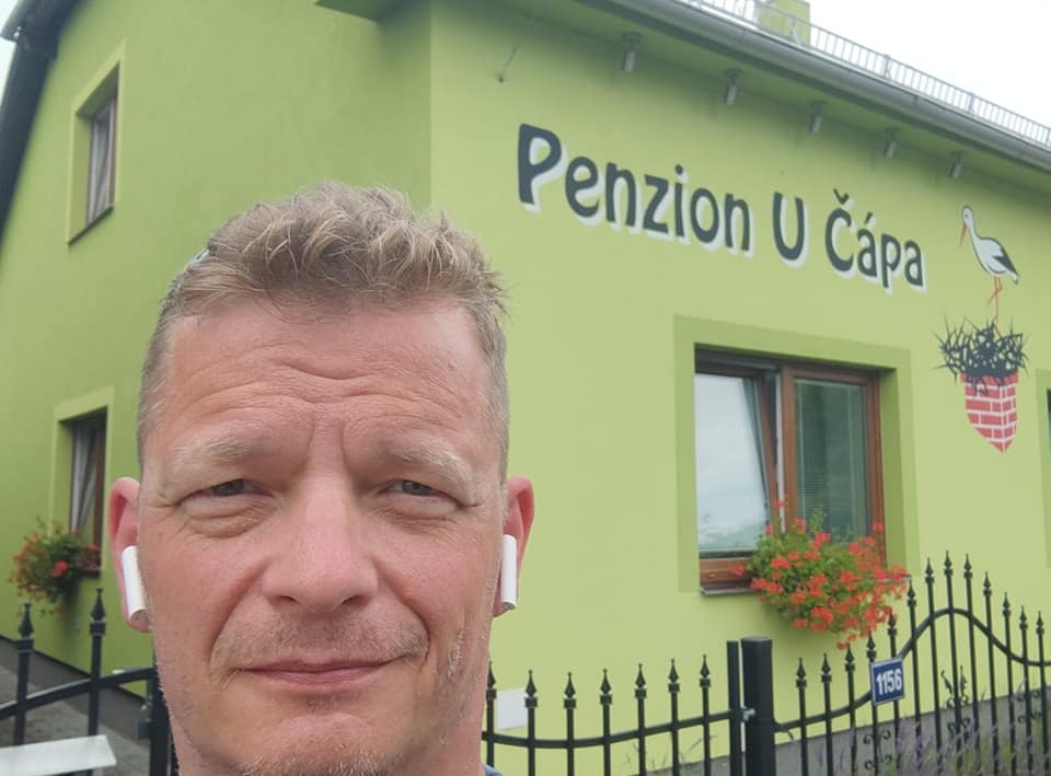 Mężczyzna przez budynkiem z napisem Penzion U Capa 