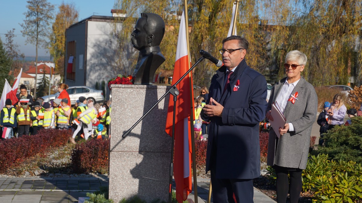 Mężczyzna w garniturze przemawia do zgromadzonych 