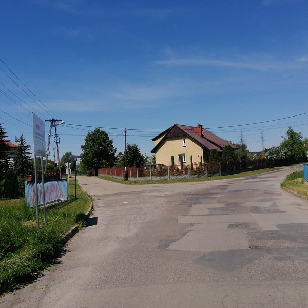 widok na ul. Waryńskiego szary asfalt po bokach drzewa