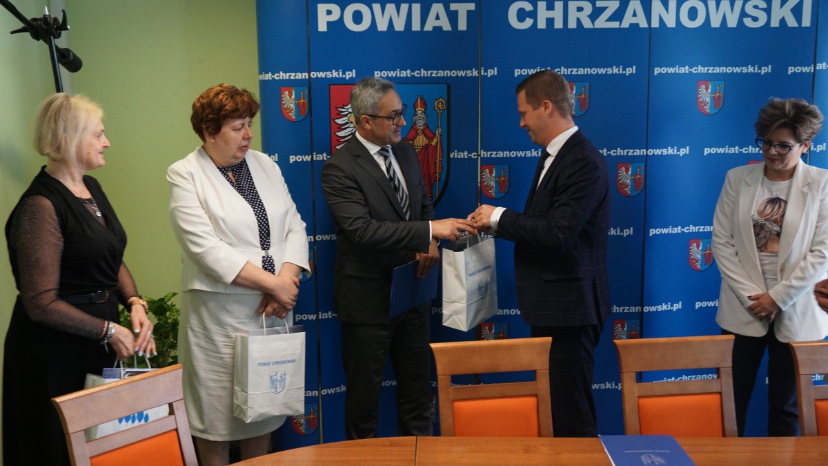 przedstawiciele powiatu wicestraosta, skarbnik, cżł. zarządu i gminy wiceburmistrz skarbnik i dyr. OPS wspólne zdjecie przekazanie upominków 