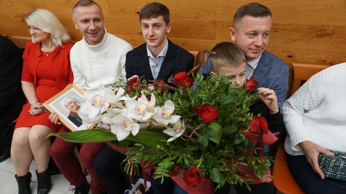 Rodzina T. Majewskiej z bukietami kwiatów 