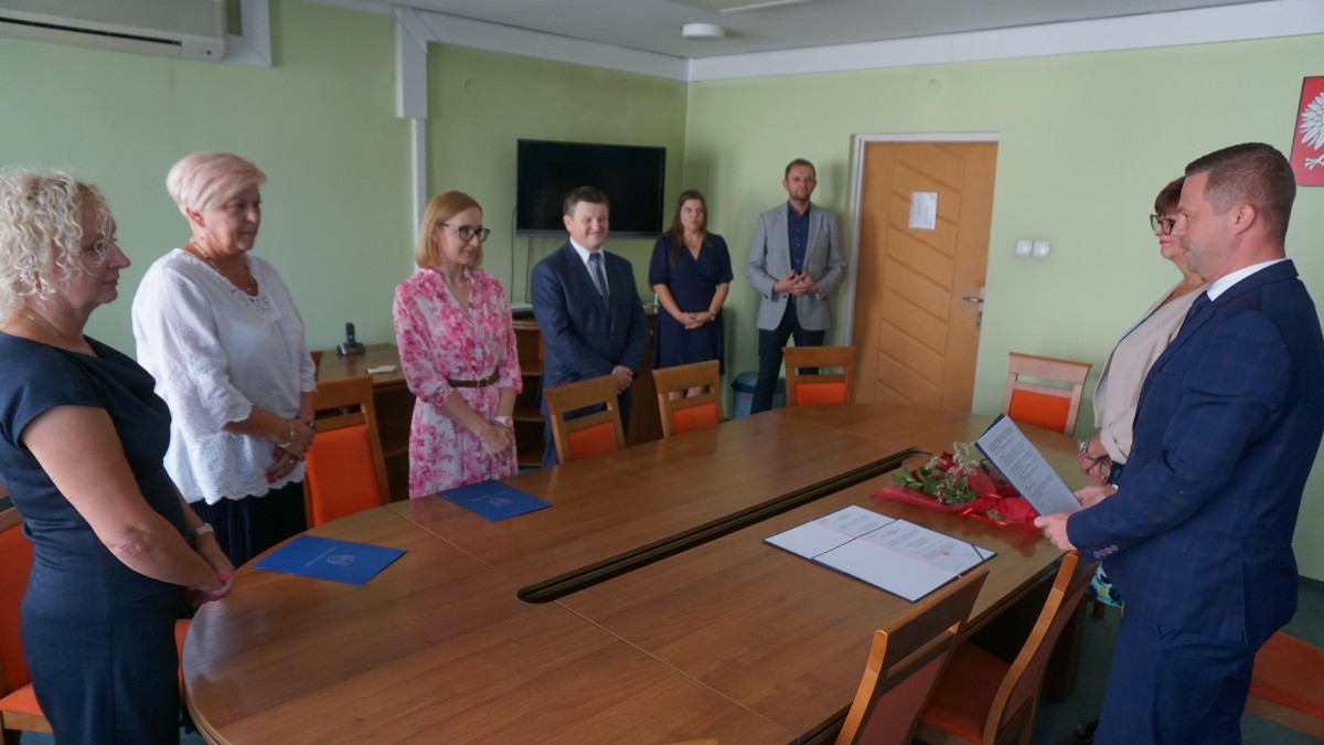 Kilka osób stoi przy dużym stole 