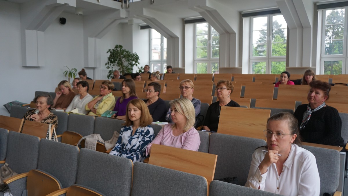 Zdjęcie kilkunastu osób na sali wykłądowej.