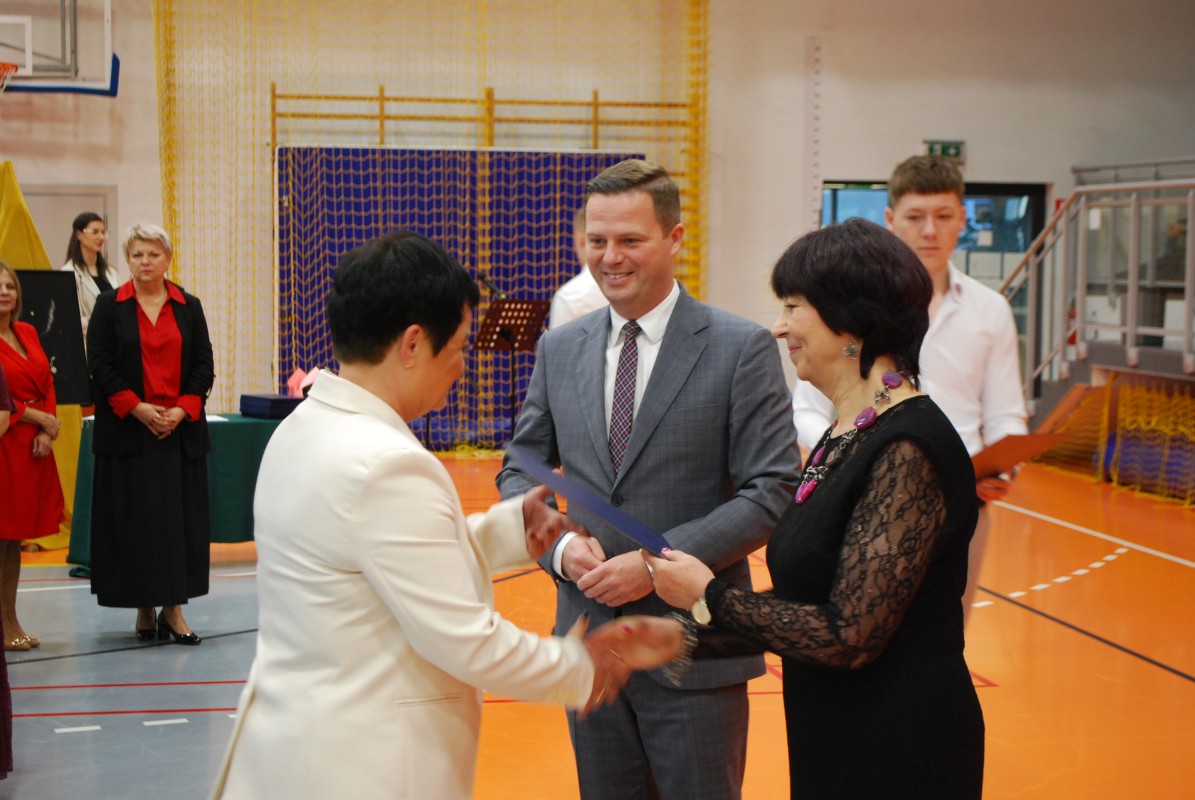 Kobieta i mężczyzna gratulują innej kobiecie.