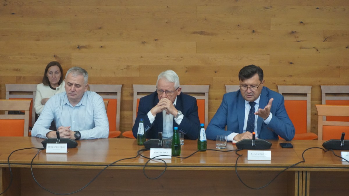 Zdjęcie trzech mężczyzn siedzących za stołem.