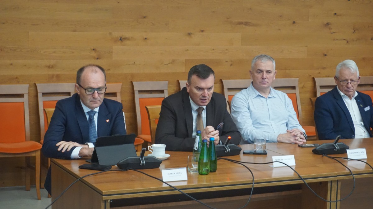 Zdjęcie trzech mężczyzn siedzących za stołem.