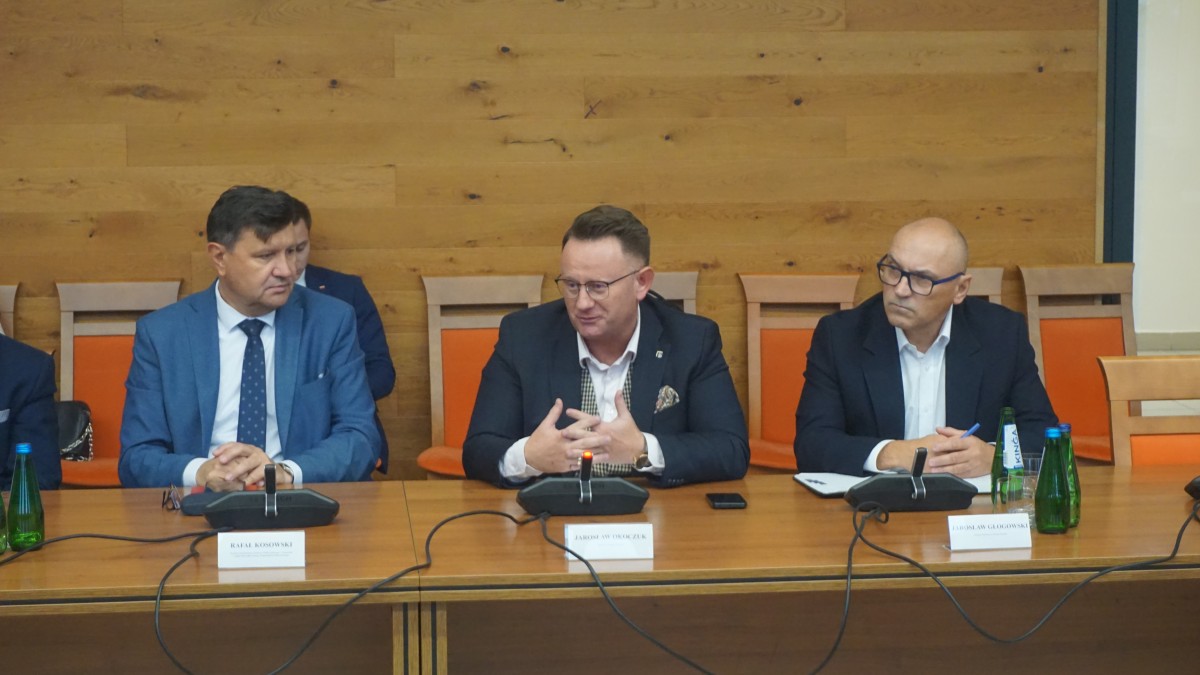 Zdjęcie trzech mężczyzn siedzących za stołem.