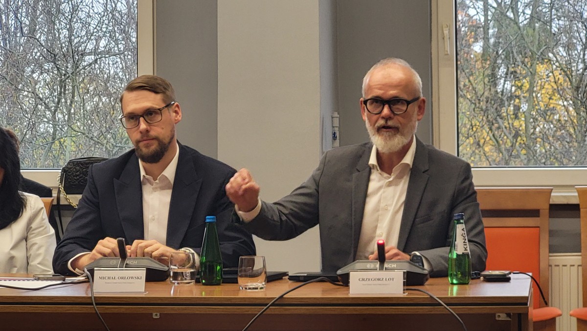 Zdjęcie trzech mężczyzn siedzących za stołem.