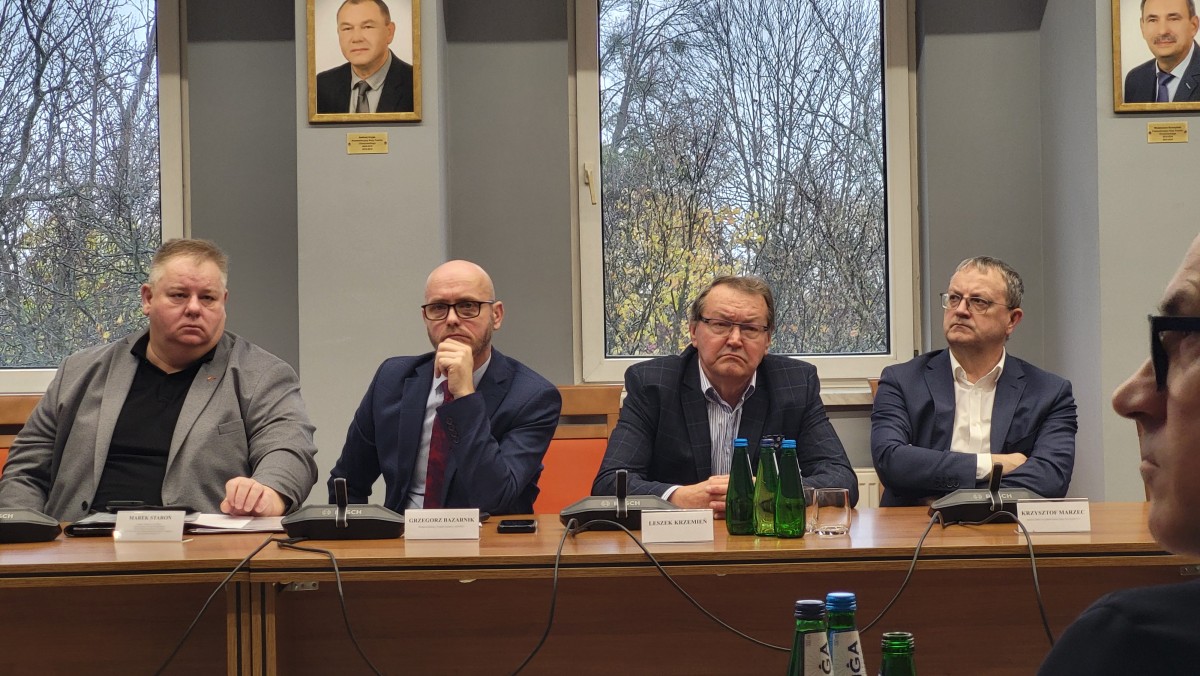 Zdjęcie czterech mężczyzn siedzących za stołem.