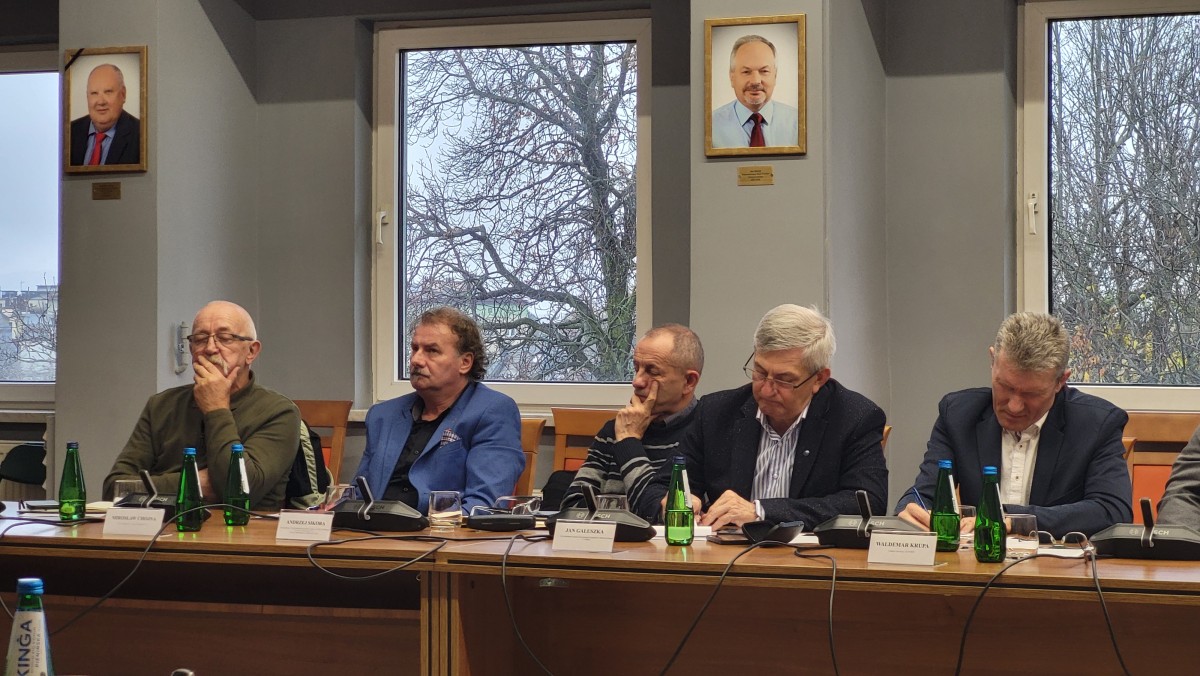 Zdjęcie pięciu mężczyzn siedzących za stołem.
