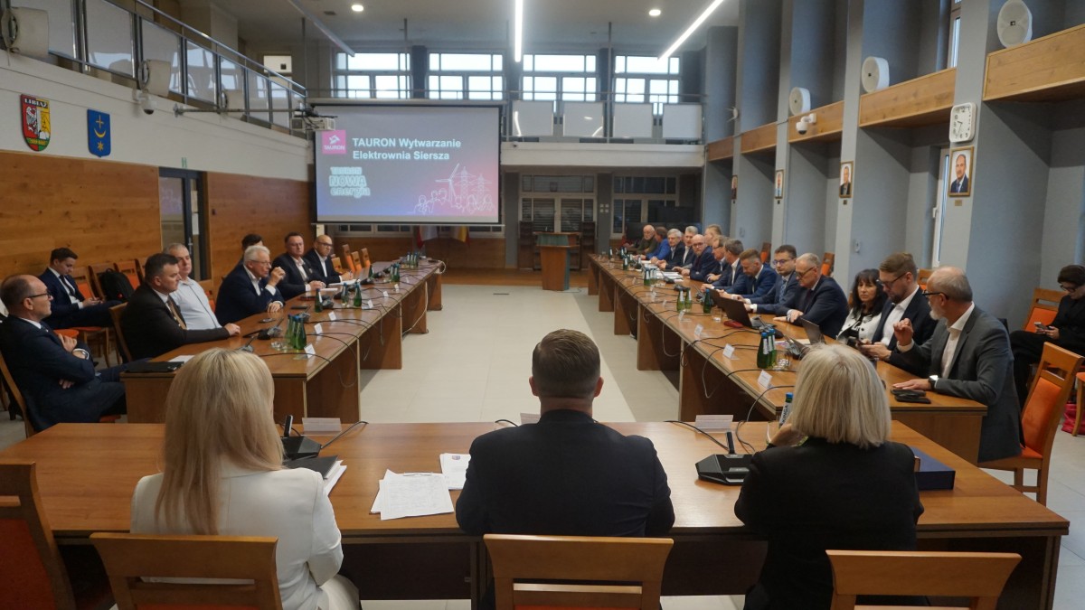 Zdjęcie sali, na której siedzi przy stołach kilkudziesięciu osób.
