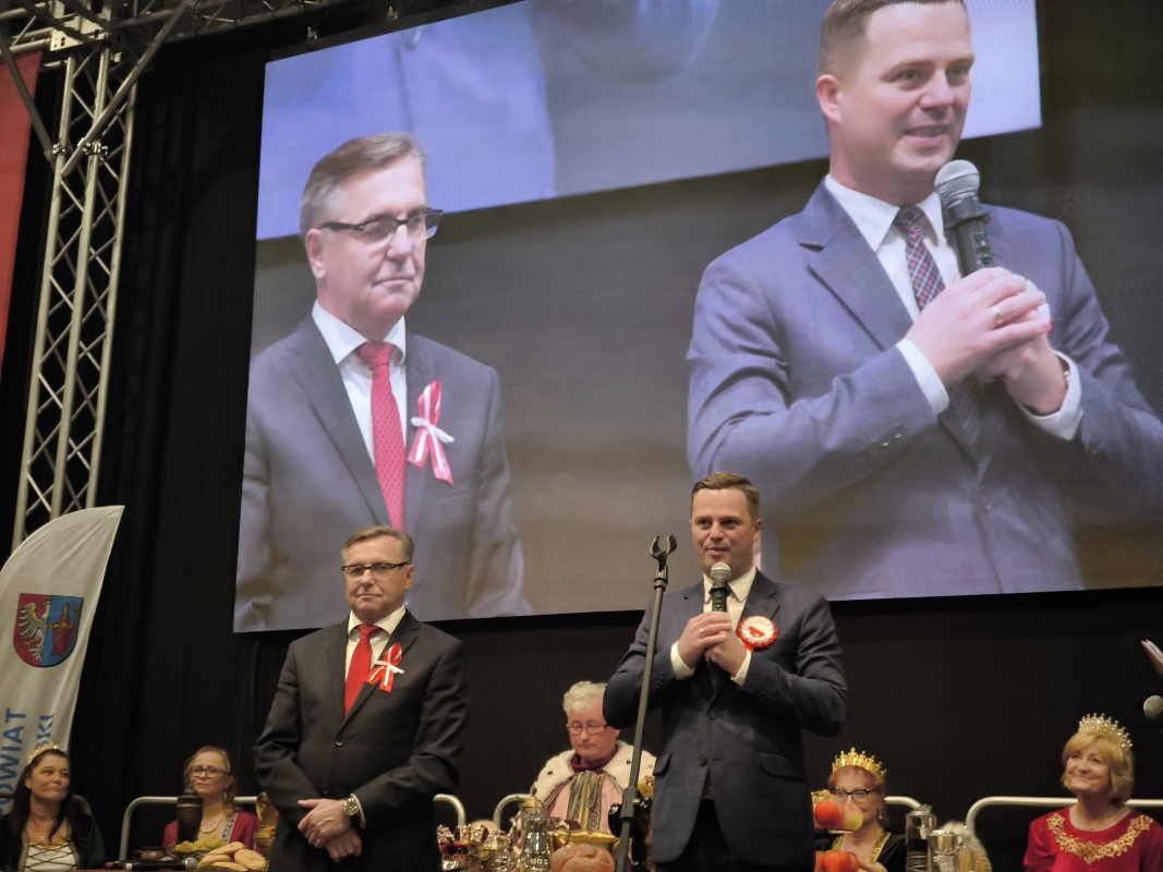 Dwóch mężczyzn na scenie, za nimi telebim