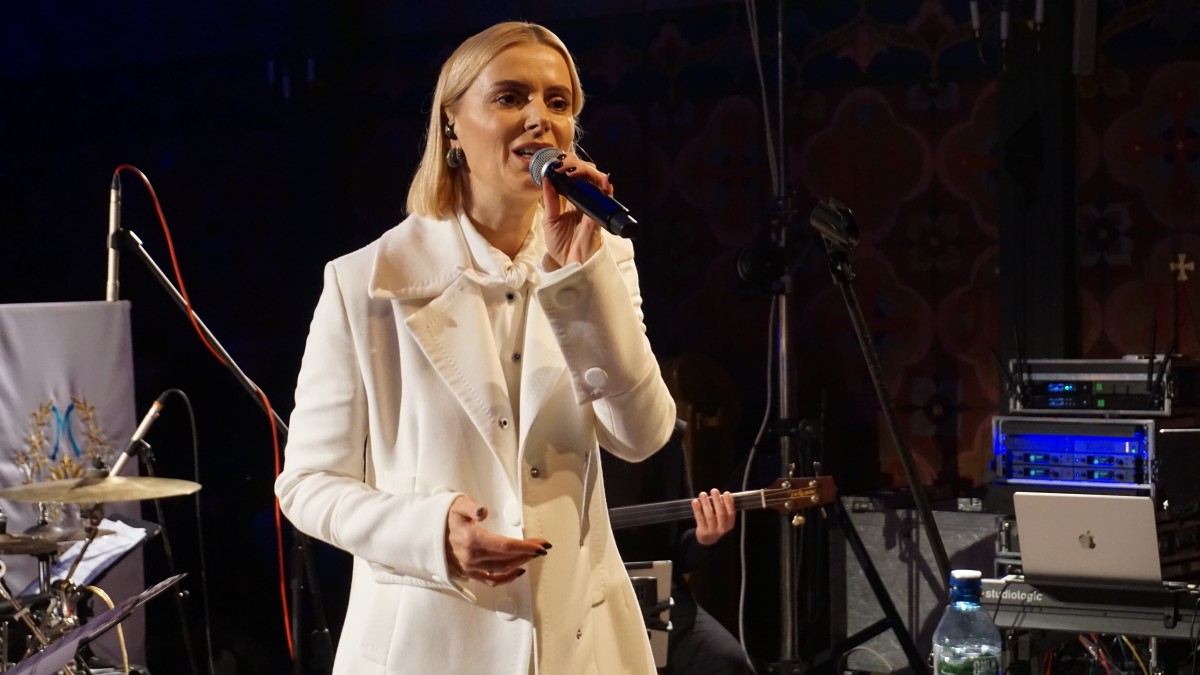 Kobieta śpiewa do mikrofonu. 