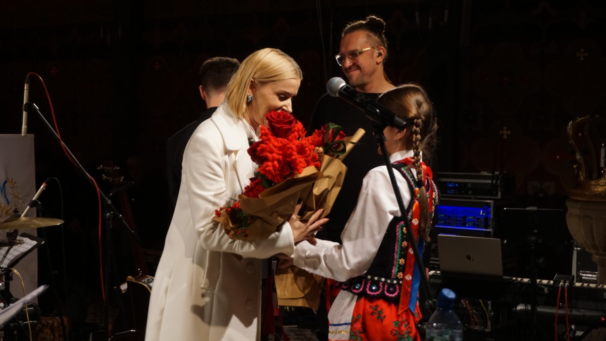 Zdjęcie kobiety odbierajacej kwiaty od dziewczynki.