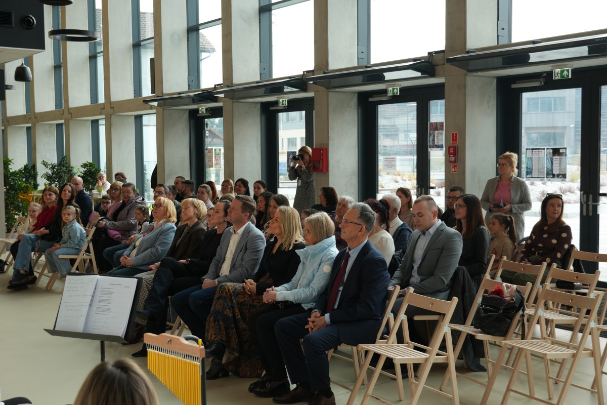 Zdjęcie uczestników wydarzenia siedzących na krzesłach.