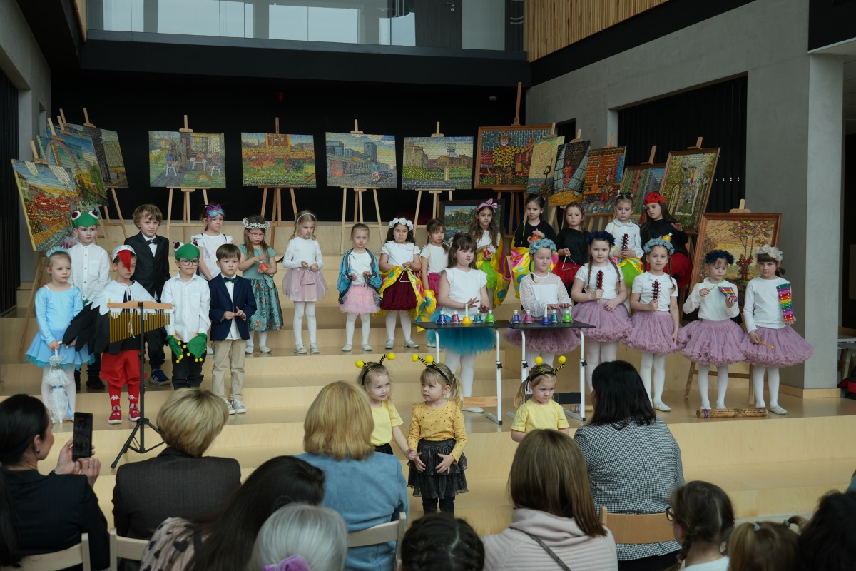 Zdjęcie kilkunastu dzieci relizujących przedstawienie artystyczne dla zebranych.