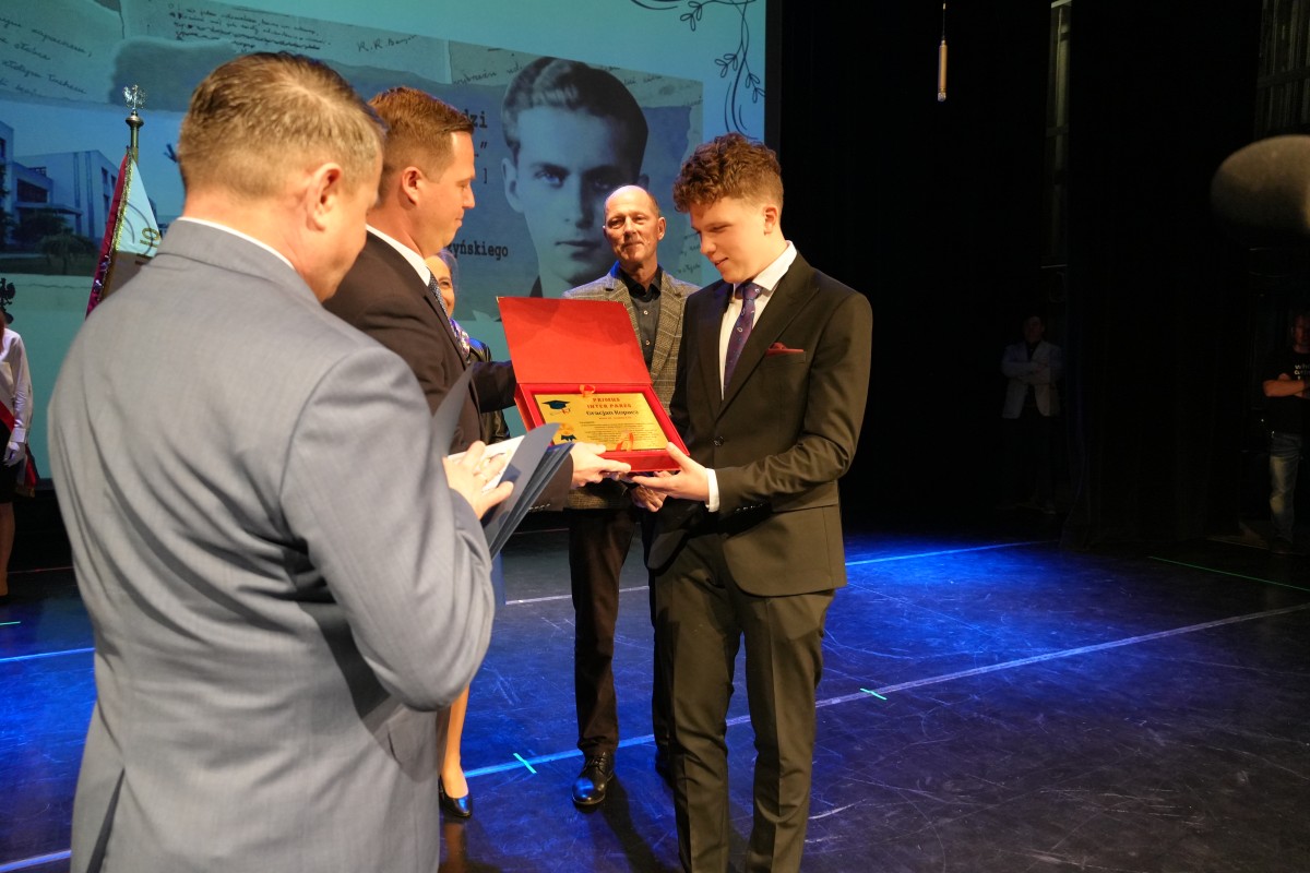 Starosta przekazuje uczniowi wyróżnienie.