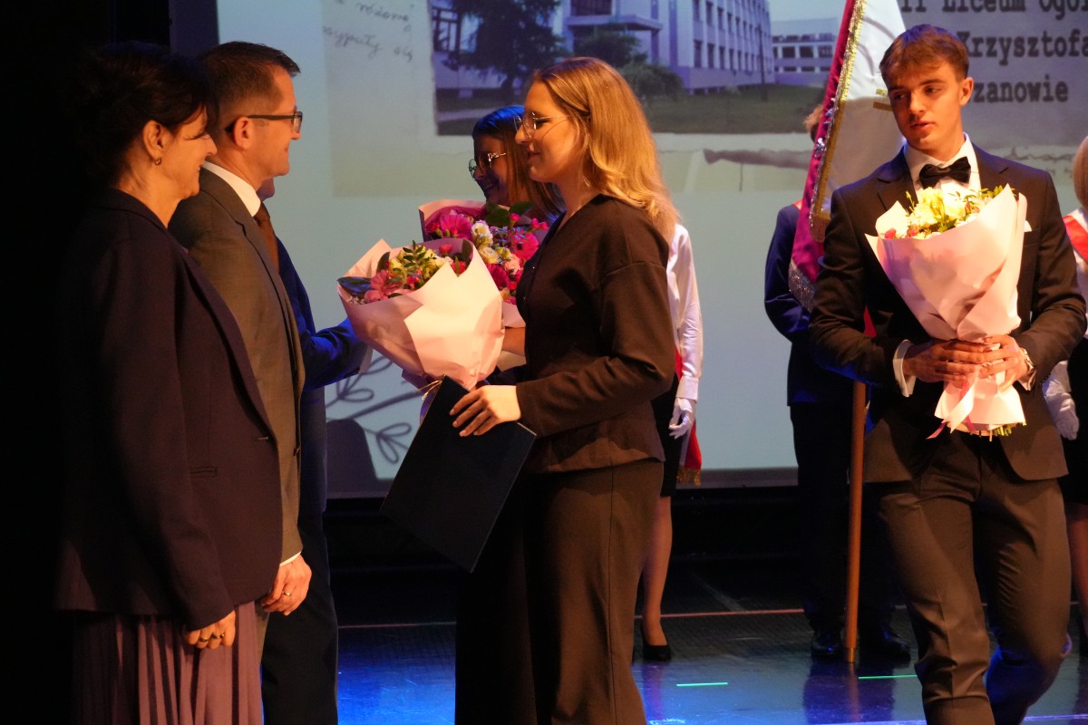 Uczniowie przekazują kwiaty nauczycielom.