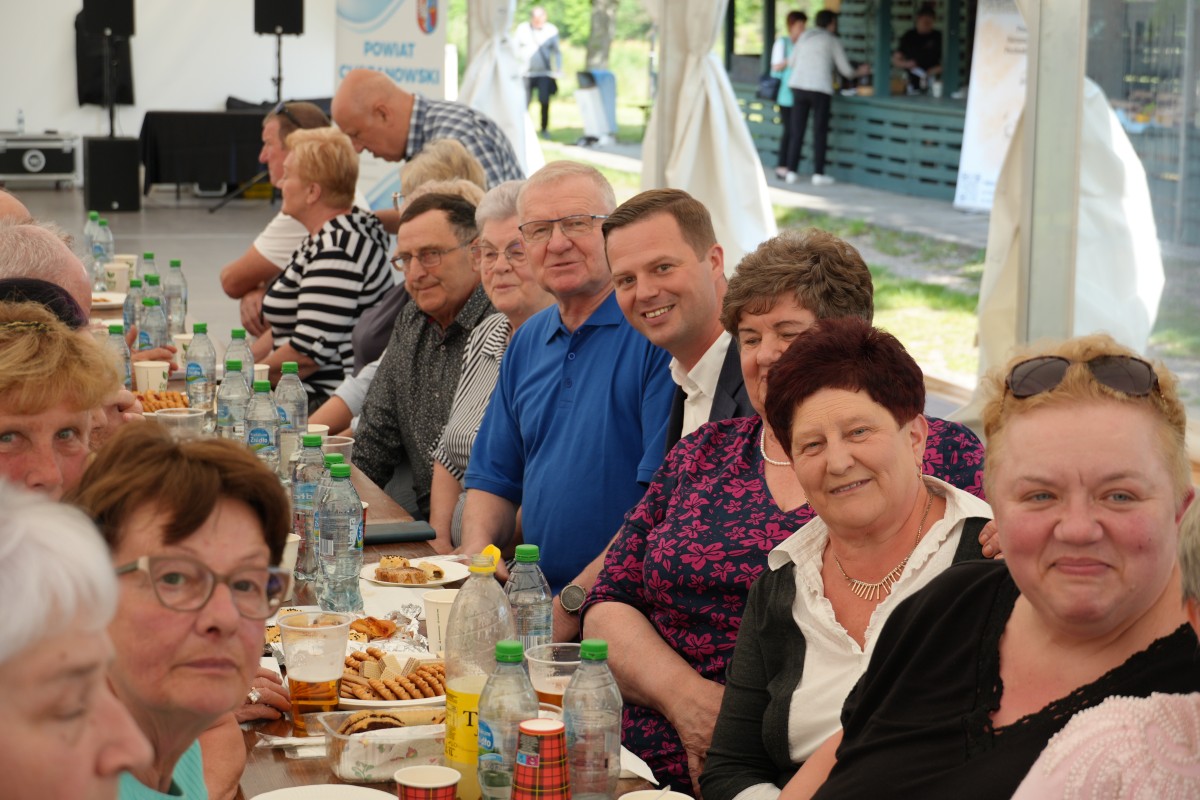 Starosta siedzacy przy stoliku z grupą seniorów.