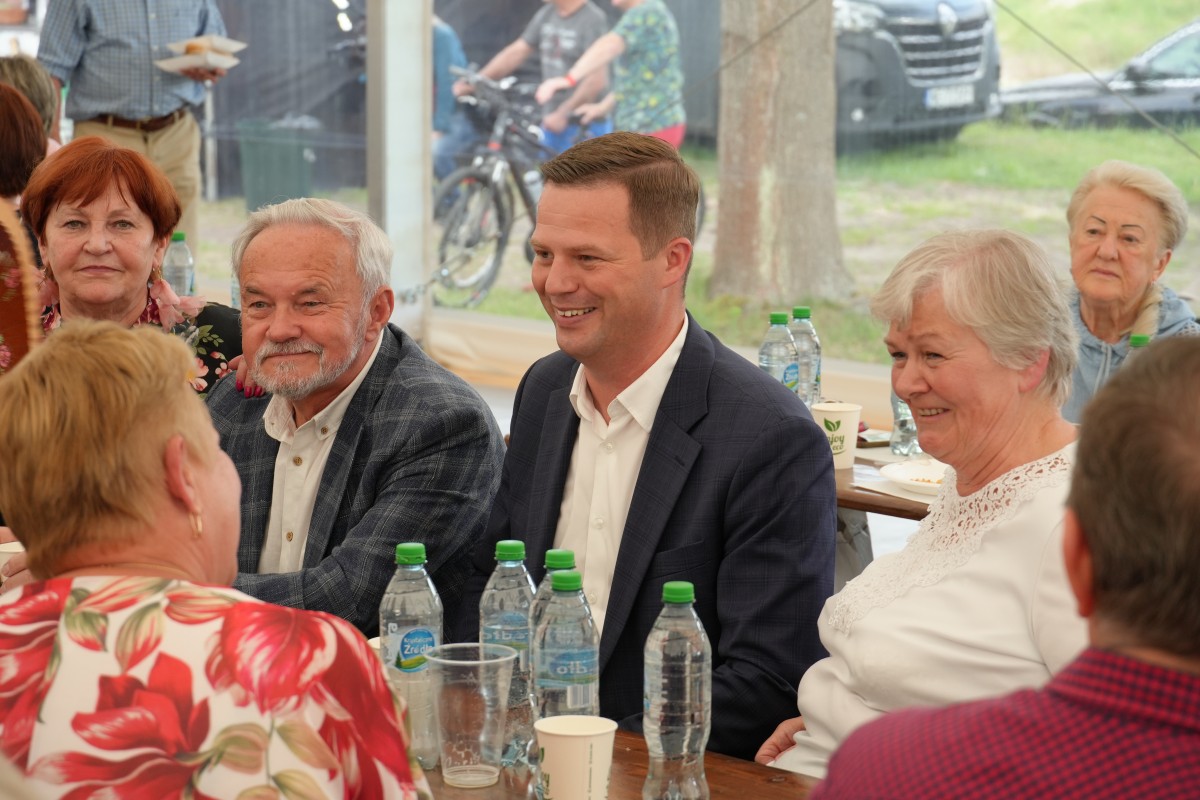 Starosta siedzacy przy stoliku z grupą seniorów.