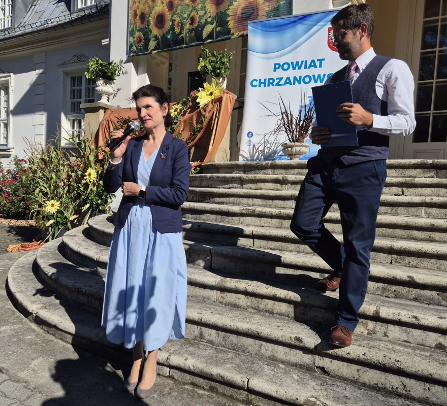 Dyrektor Kazimiera Żmudzińska wita gości stojąc na schodach pałacu Starzeńskich w Płazie. Obok jeden z pracowników
