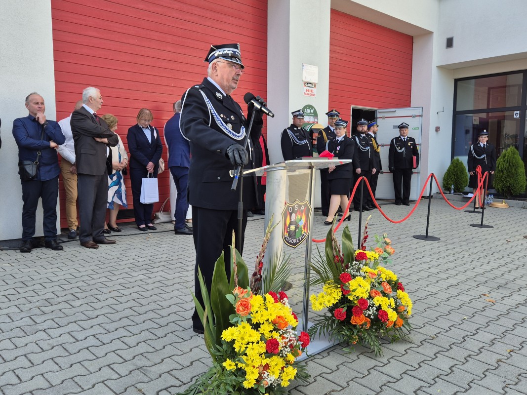 Marek Bębenek stoi przy mównicy i gratuluje ochotnikom OSP Pogorzyce