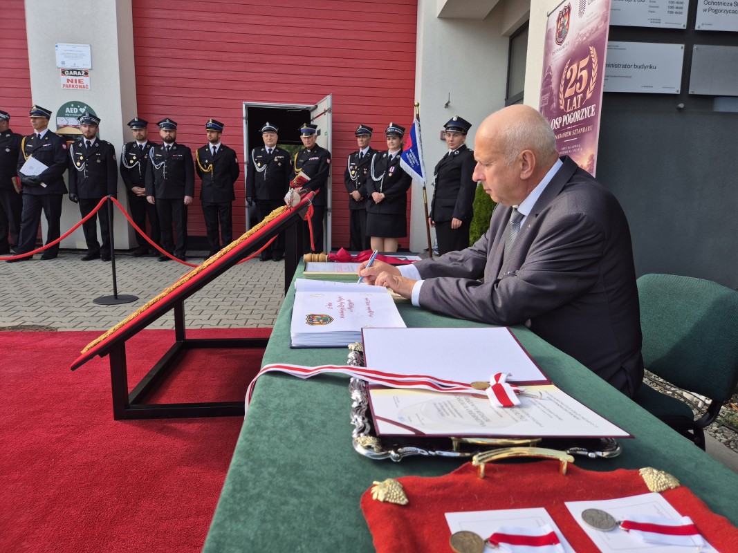 Sołtys Janusz Krupnik wpisuje sie do księgi pamiątkowej