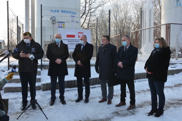 wojewoda małopolski, dyrektor szpitala starosta chrzanowski i przedstawiciele szpitala stojący na dworze , w tle mikrofony  , tablica dofinansowano z budżetu państwa 