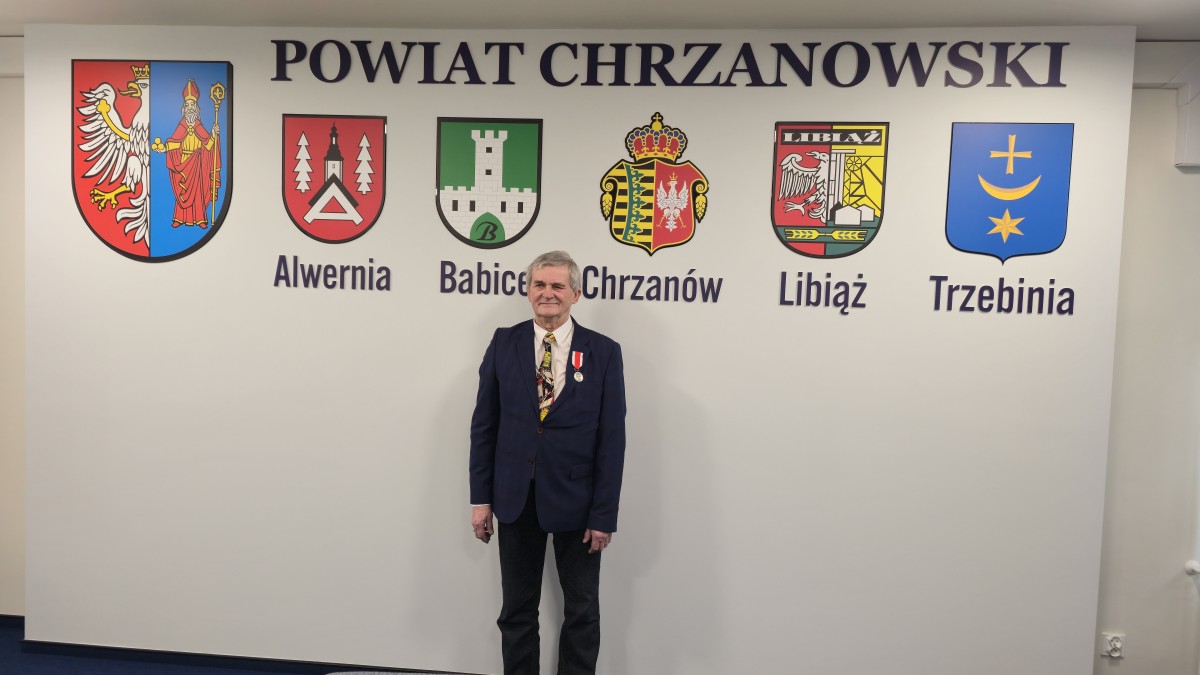 Zdjęcie mężczyzny w garniturze wraz z medalem.