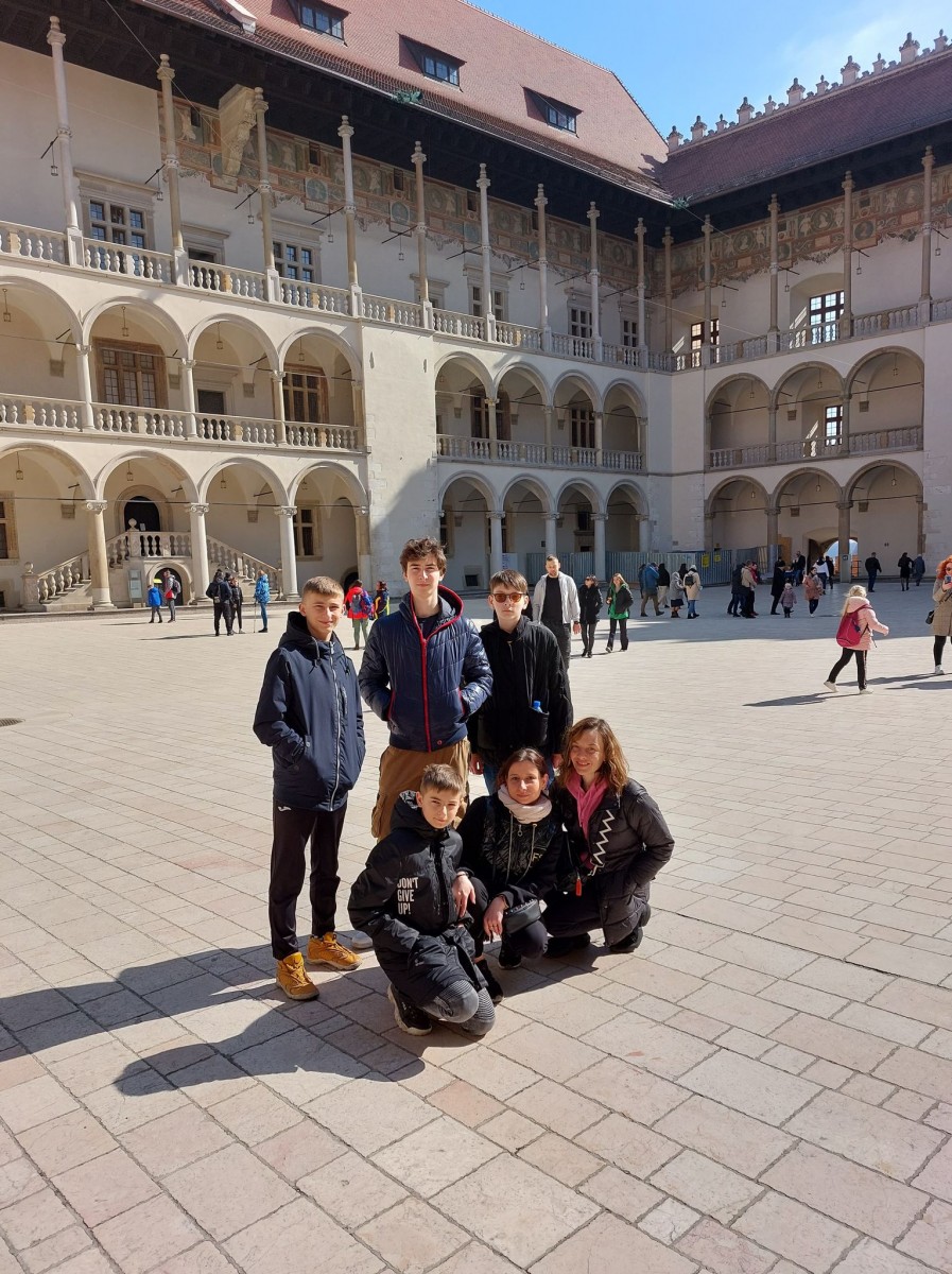 Dwie kobiety i czterech nastolatków, w tle zamek na Wawelu 