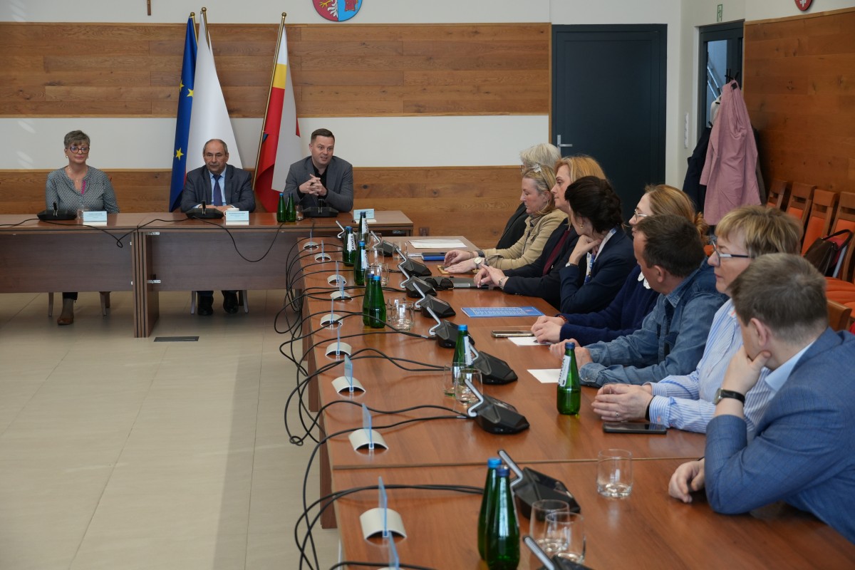 Zdjęcie kilkudziesięciu osób na sali narad siedzących przy stołach.