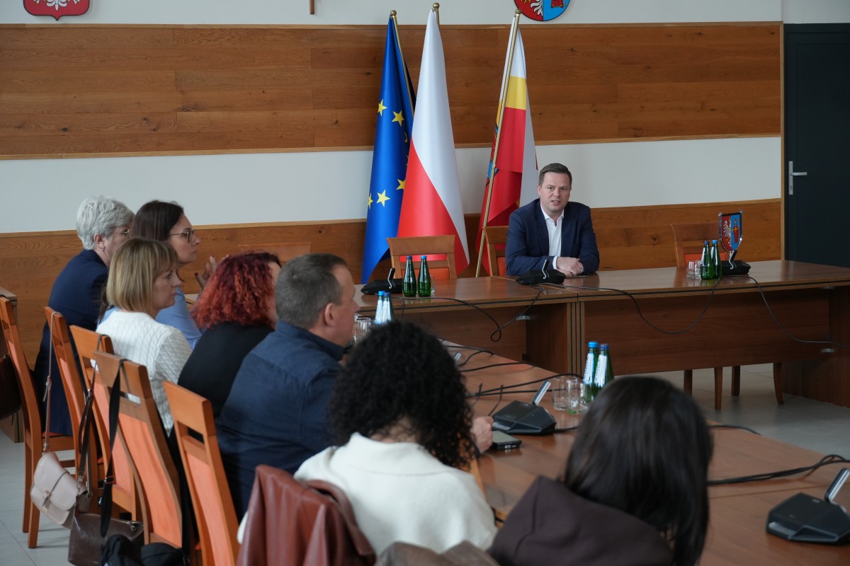 Zdjęcie kilkudziesięciu osób na sali narad siedzących przy stołach