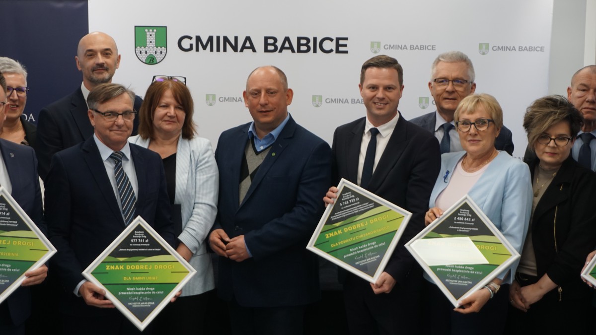 Wspólna fotografia jedynastu osób. Niektóre z osób trzymają tabliczki w ramkach.