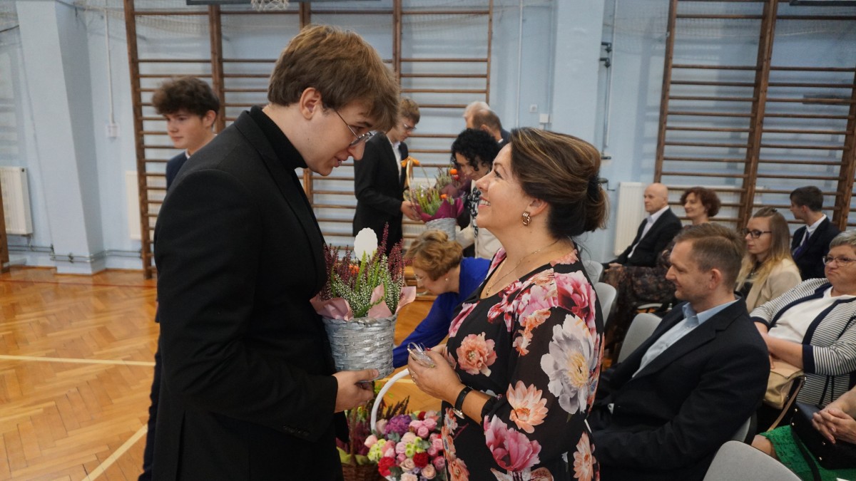Uczeń wręcza kwiaty nauczycielce 