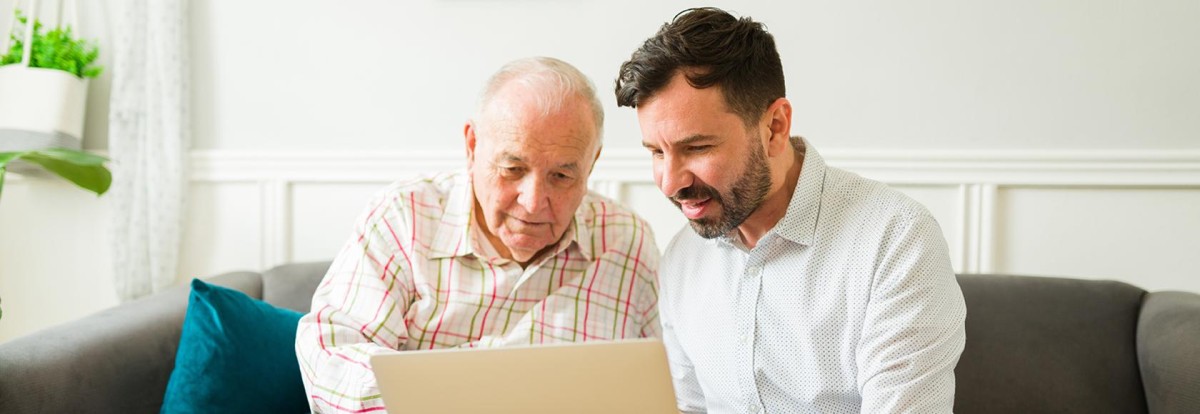 Starszy i młodszy mężczyzna przed laptopem 