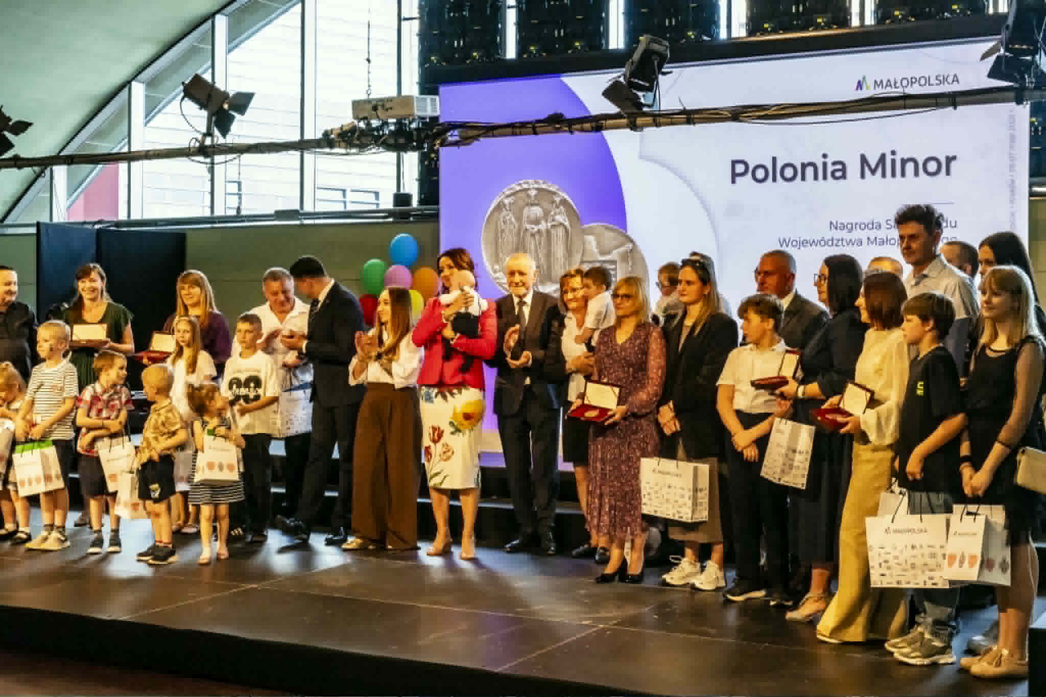 Dzieci i dorośli z rodzin zastępczych pozują do zdjęcia