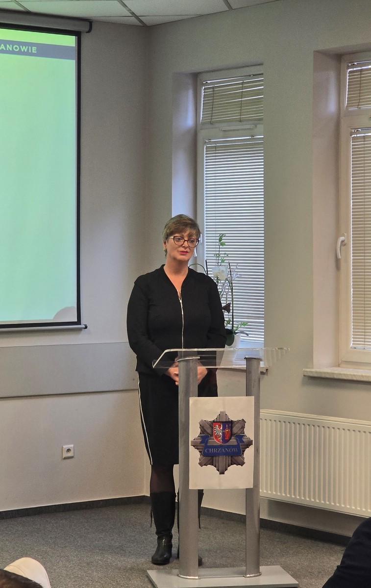 Zdjęcie kobiety stojącej za mównicą.