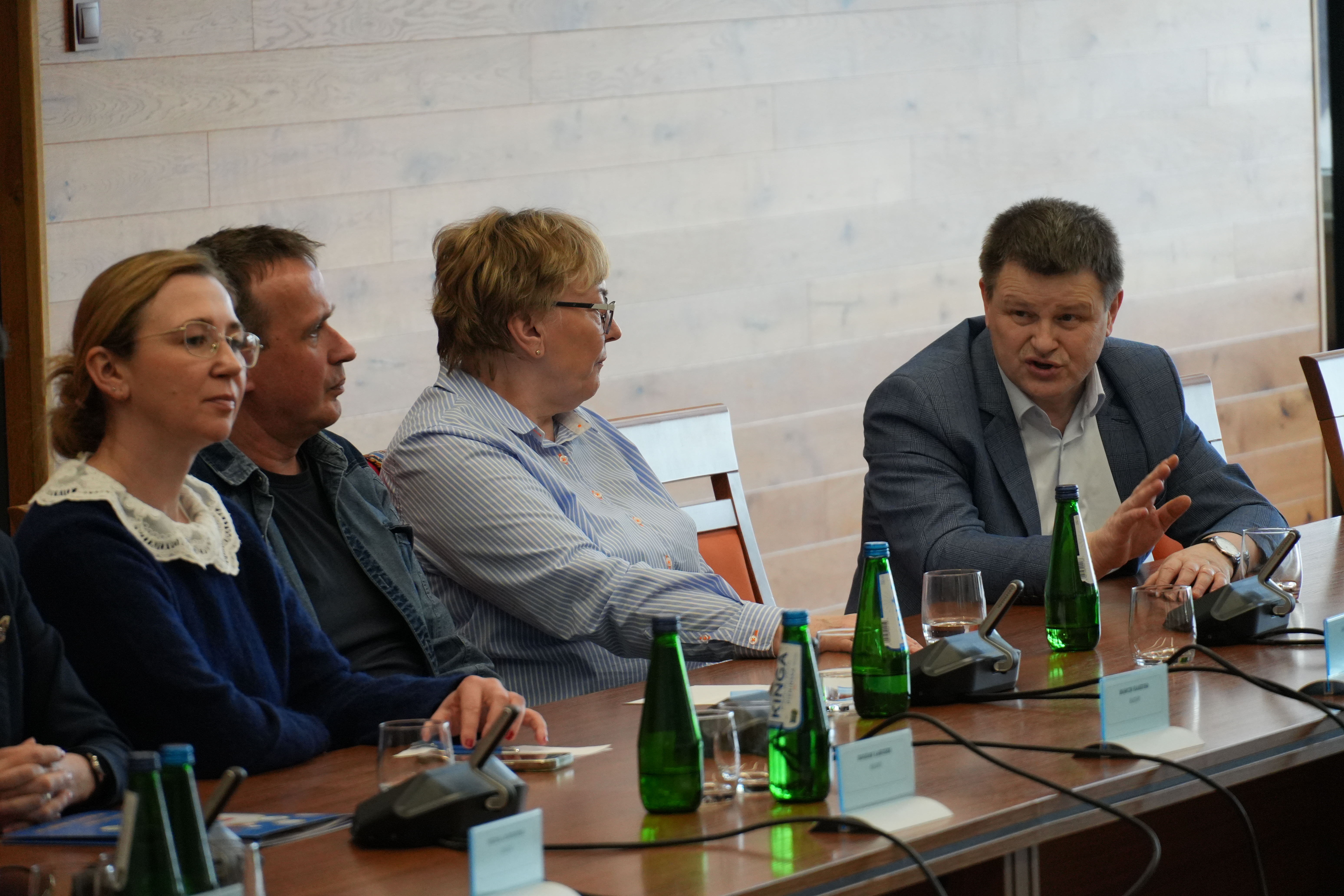 Zdjęcie kilkudziesięciu osób na sali narad siedzących przy stołach