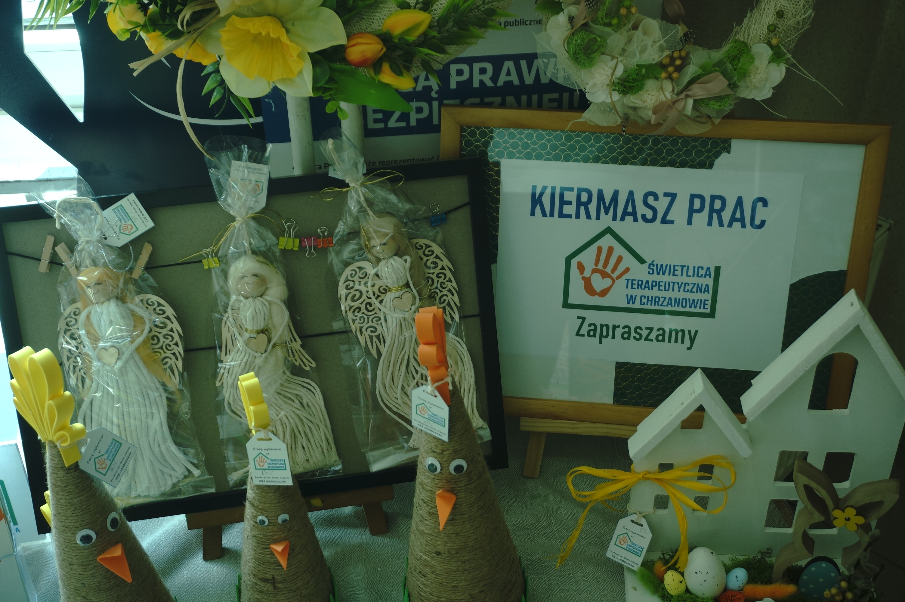 Zdjęcie wystawionych prac z rękodzieła na korytarzu wewątrz budynku