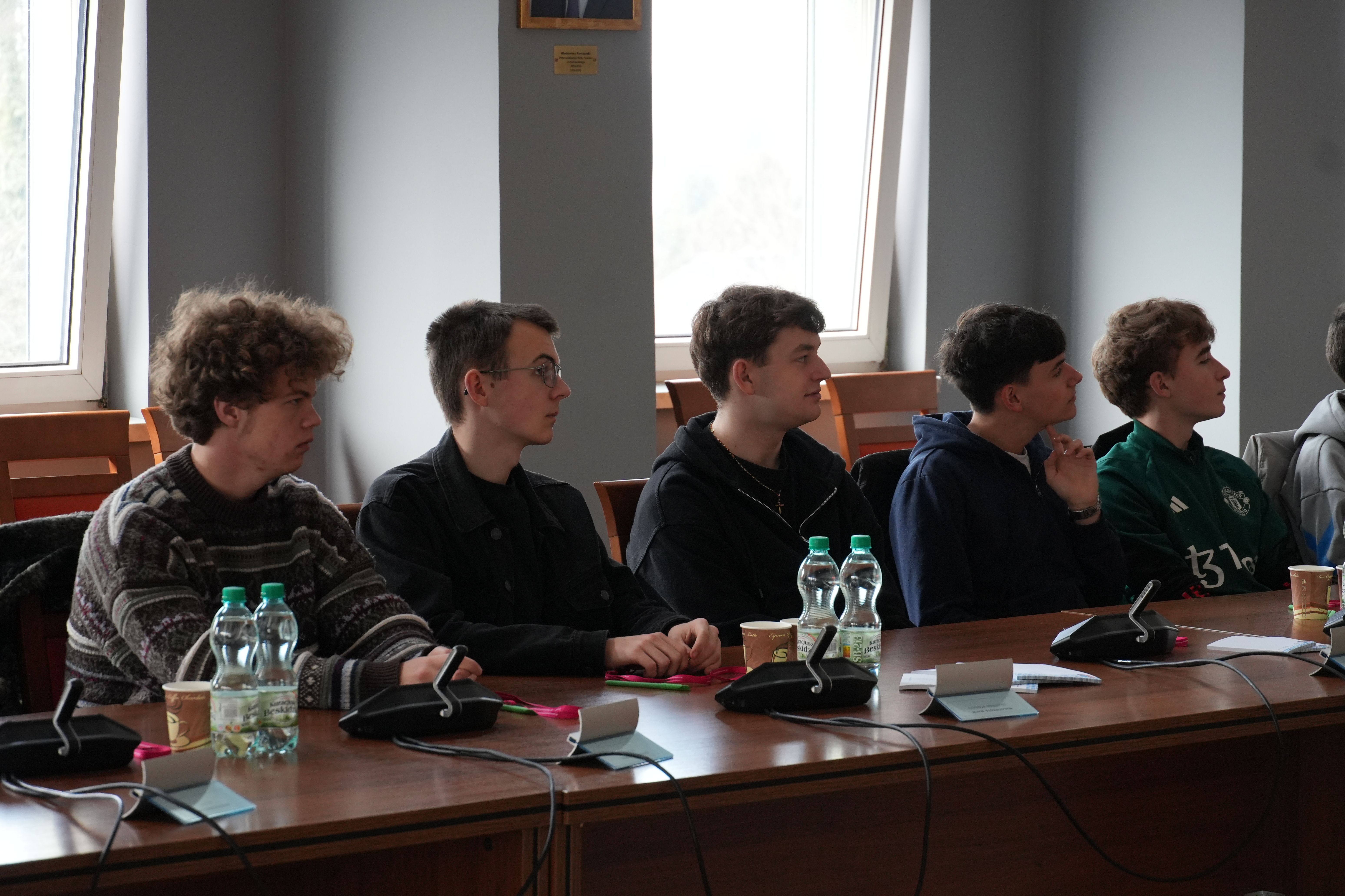 Zdjęcie kilku młodych osób siedzących przy stole.
