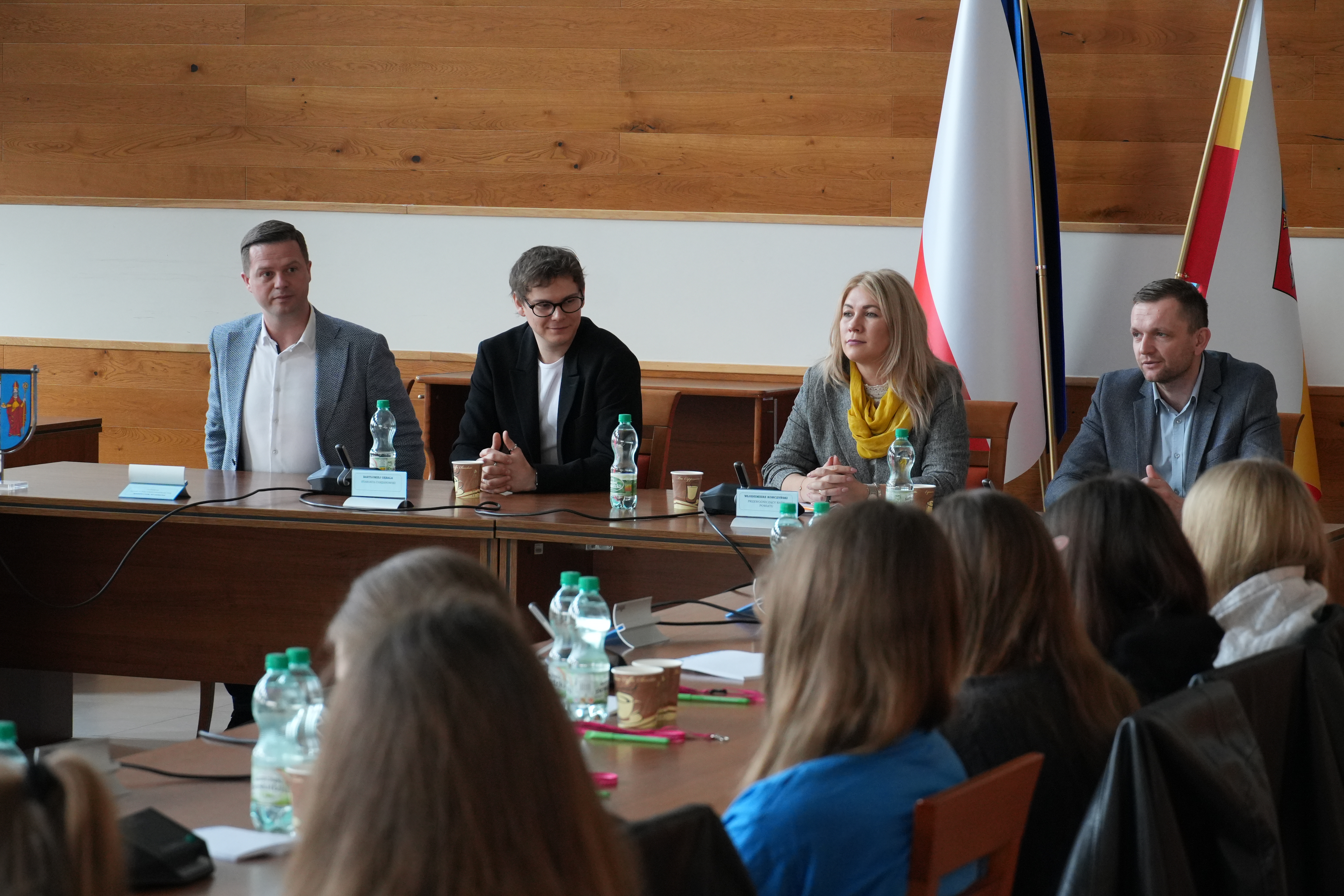 Zdjęcie czterech osób zasiadających przy stole prezydialnym.