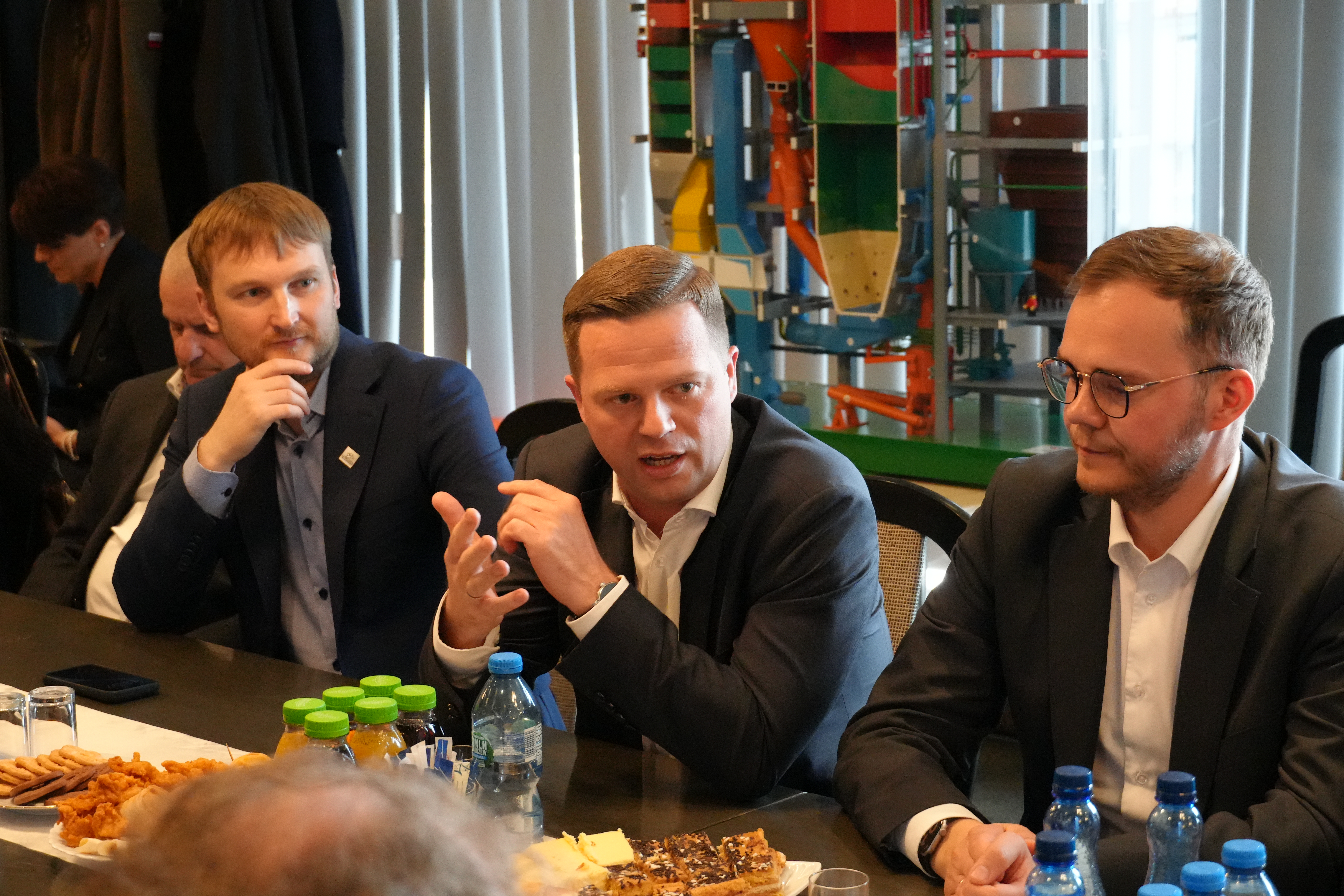 Zdjęcie kilku mężczyzn siedzących przy stole i rozmawiajacych.