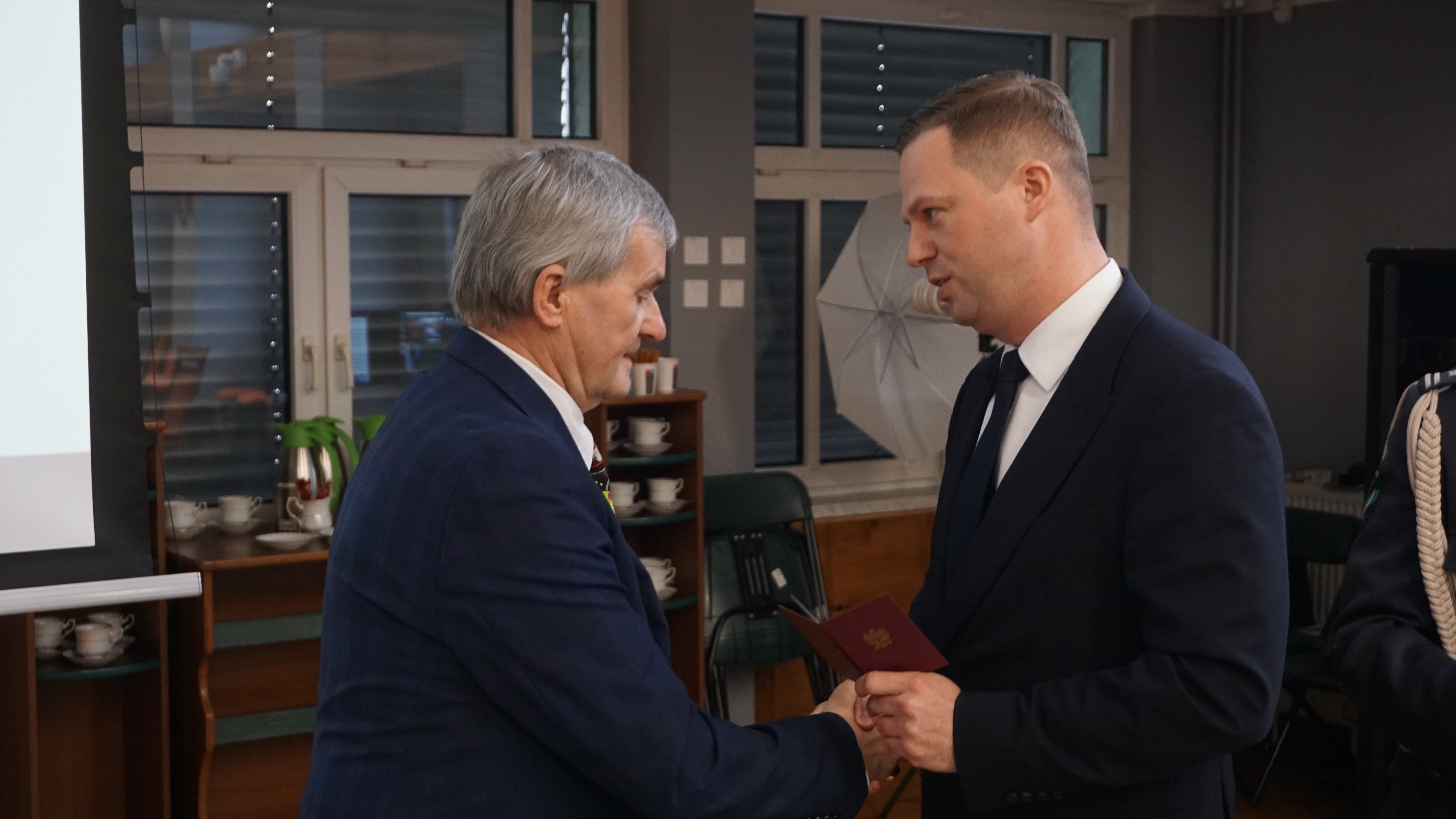 Zdjęcie mężczyzny, który odbiera gratulacje od Starosty.