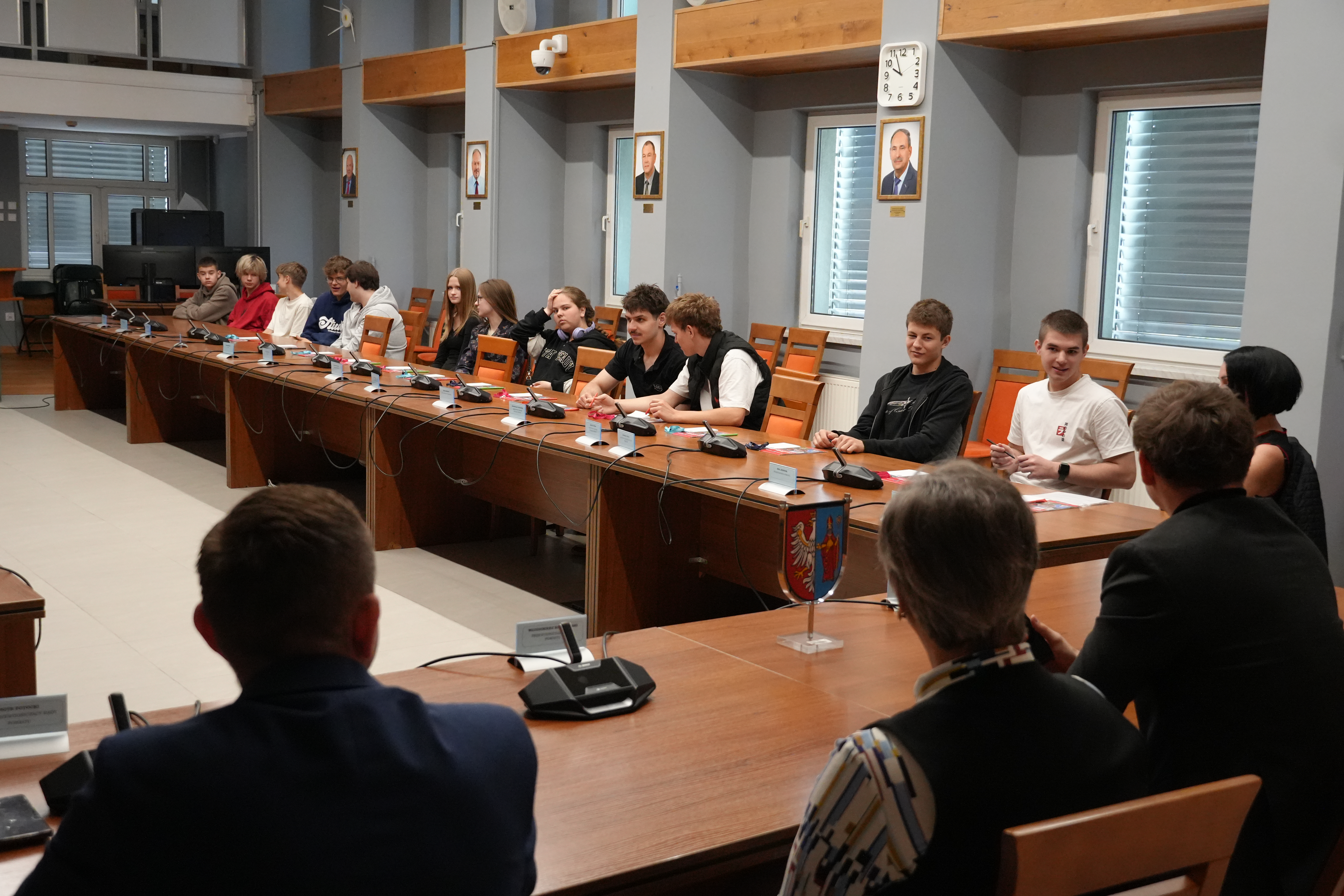 Zdjęcie kilkudziesięciu osób siedzących przy stołach na dużej sali narad.