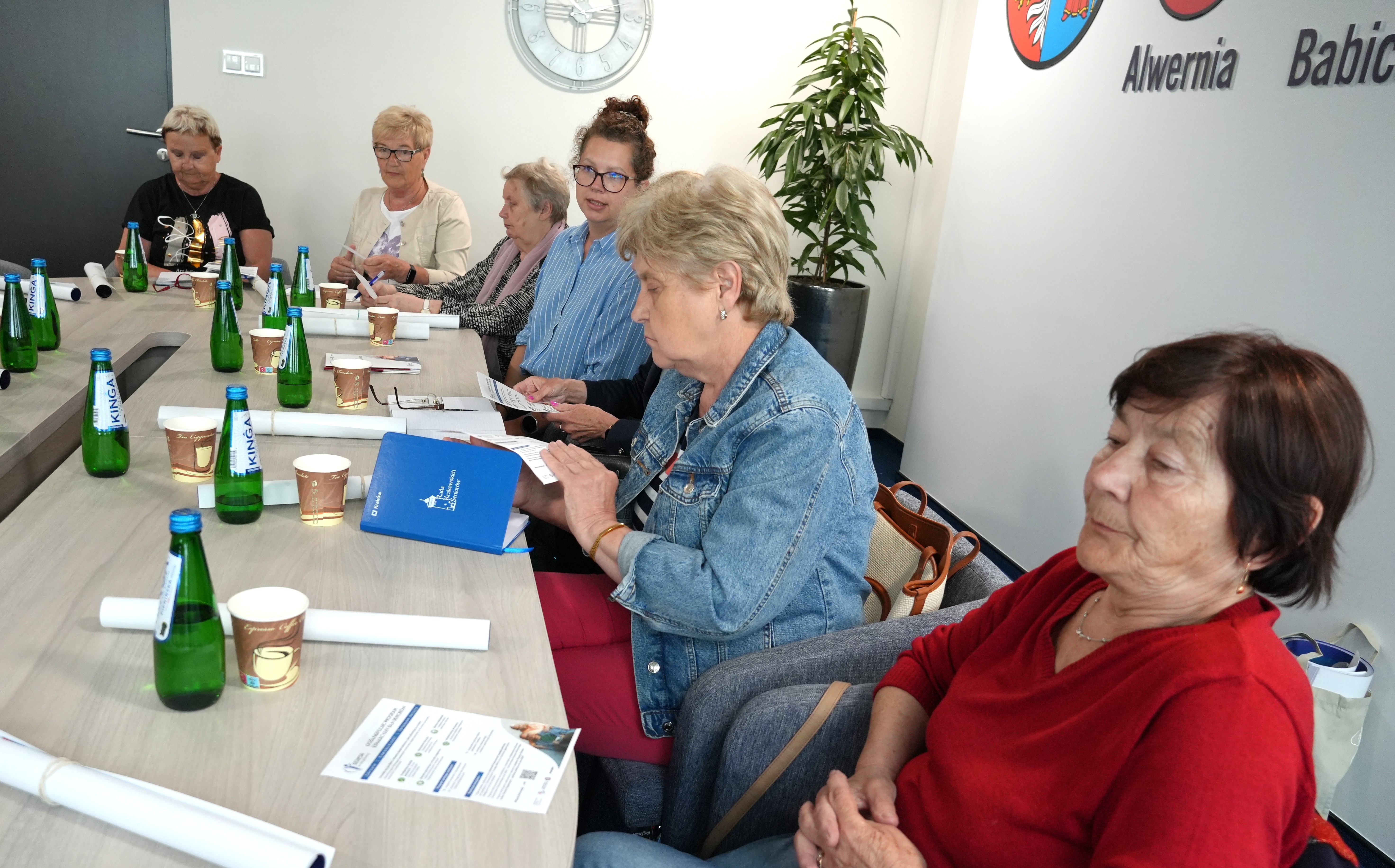 Seniorzy siedza przy stole i rozmawiają