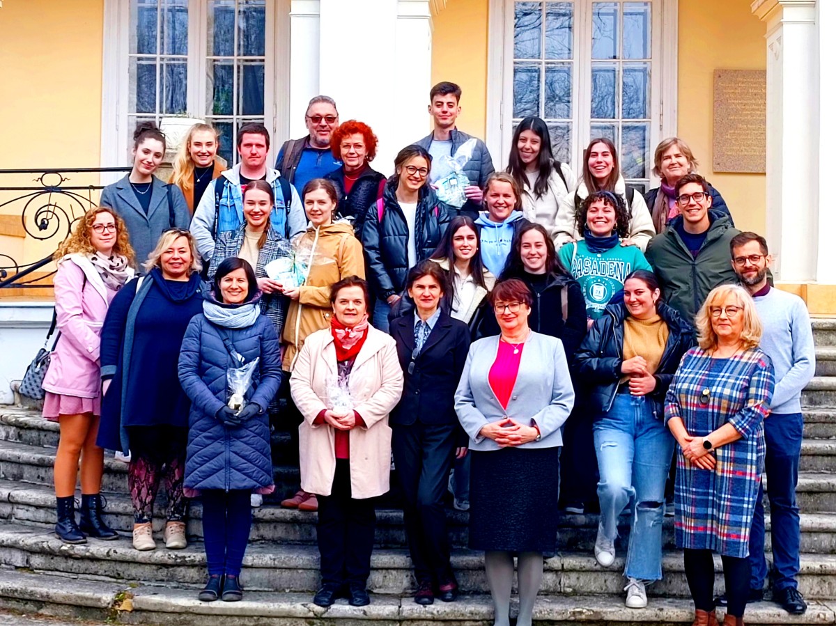 zdjęcie grupowe przedstawiciele pdps oraz studenci stoja na schodach przed budynkiem pałacu 